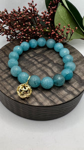 Armbånd Blå Kalsedon med en gullfarget kule charms med blomster