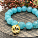 Armbånd Blå Kalsedon med en gullfarget kule charms med blomster
